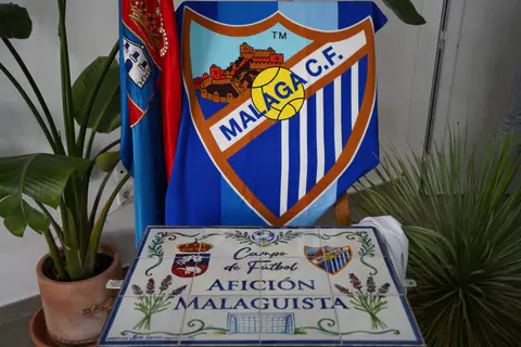 Rótulo cerámico del campo de fútbol Afición Malaguista ante un escudo blanquiazul.