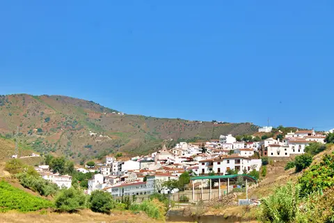 Vista del caserío blanco de El Borge entre lomas.