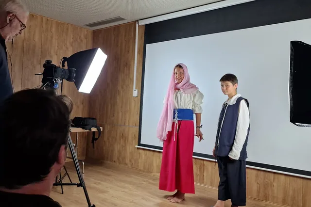Grabación audiovisual con dos personas ante un fondo blanco.