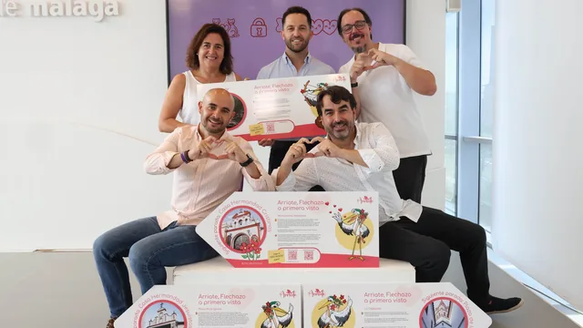 Grupo posando con paneles ilustrados de una ruta turística.