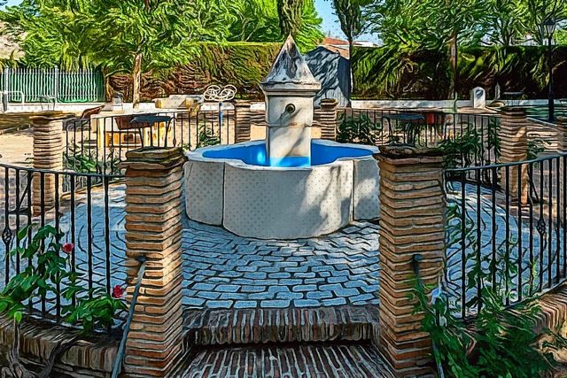 Fuente circular de piedra en un jardín sombreado.