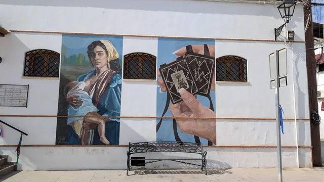 Mural de una mujer artesana pintado en una fachada.