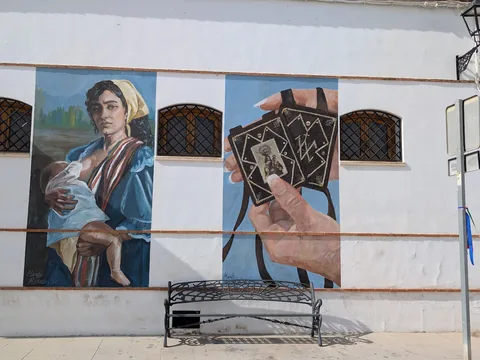 Mural de una mujer artesana pintado en una fachada.