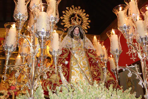 Imagen de Nuestra Señora de la Fuensanta entre candelabros encendidos.